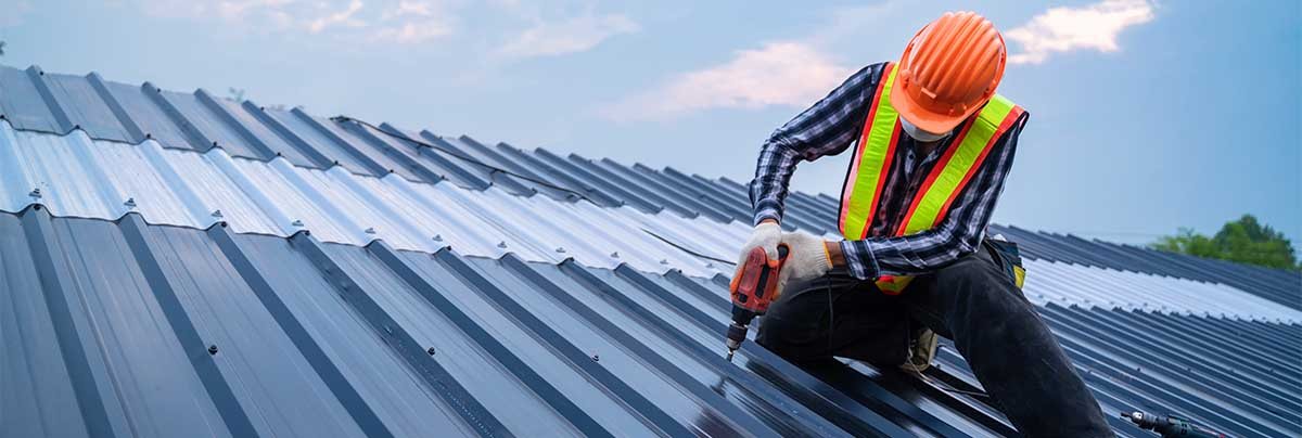 Worker with orange helmet on a metal roof (stock; banner of About/Services/Contact)