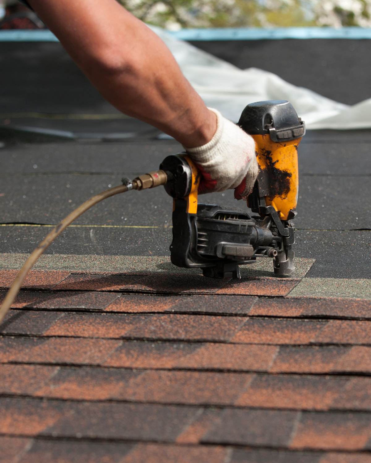 Nail gun on brown shingles (stock; hero Shingle Roof and card)