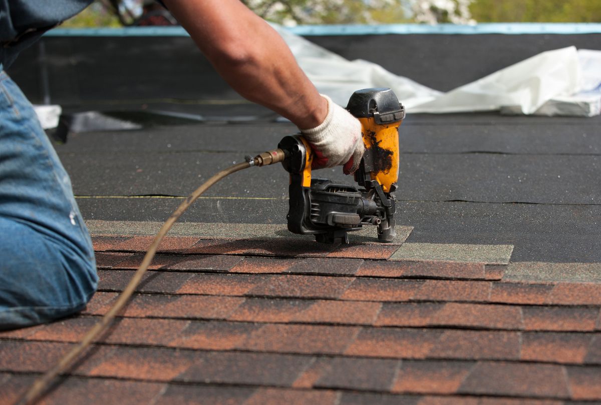 Nail gun on brown shingles (stock; hero Shingle Roof and card)