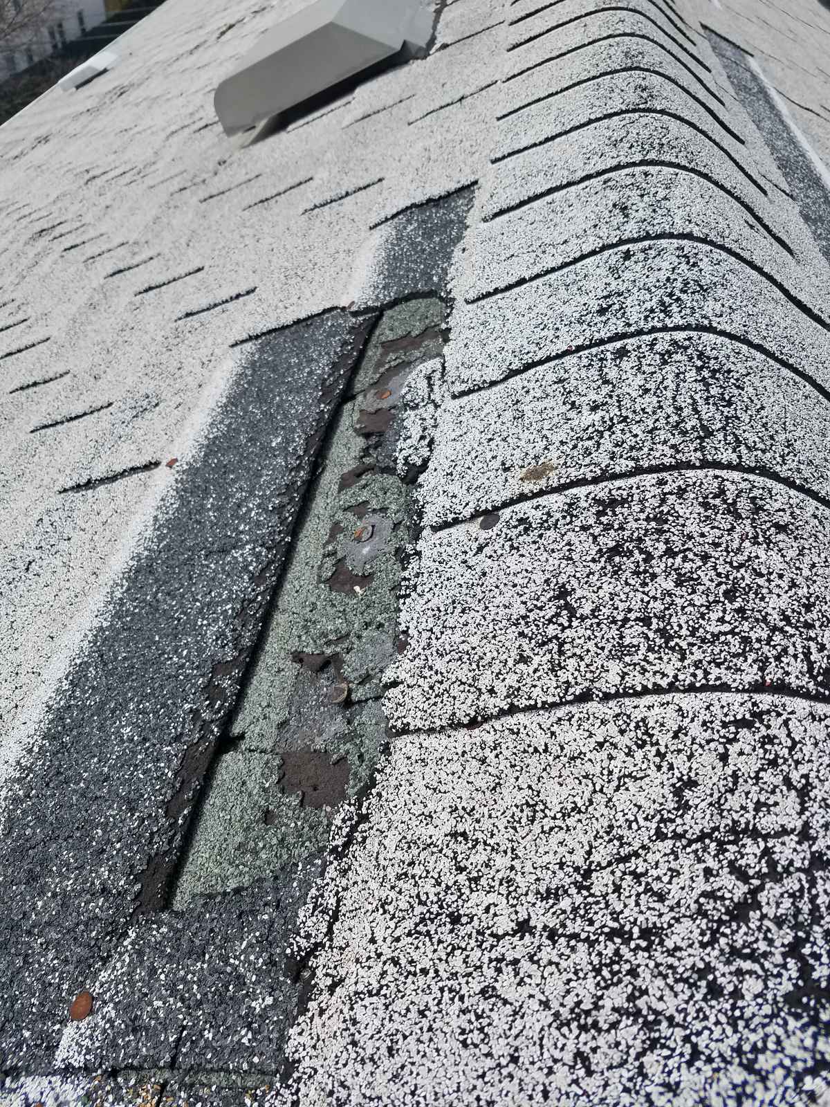 Shingle roof with a missing shingle section exposing the deck before repair