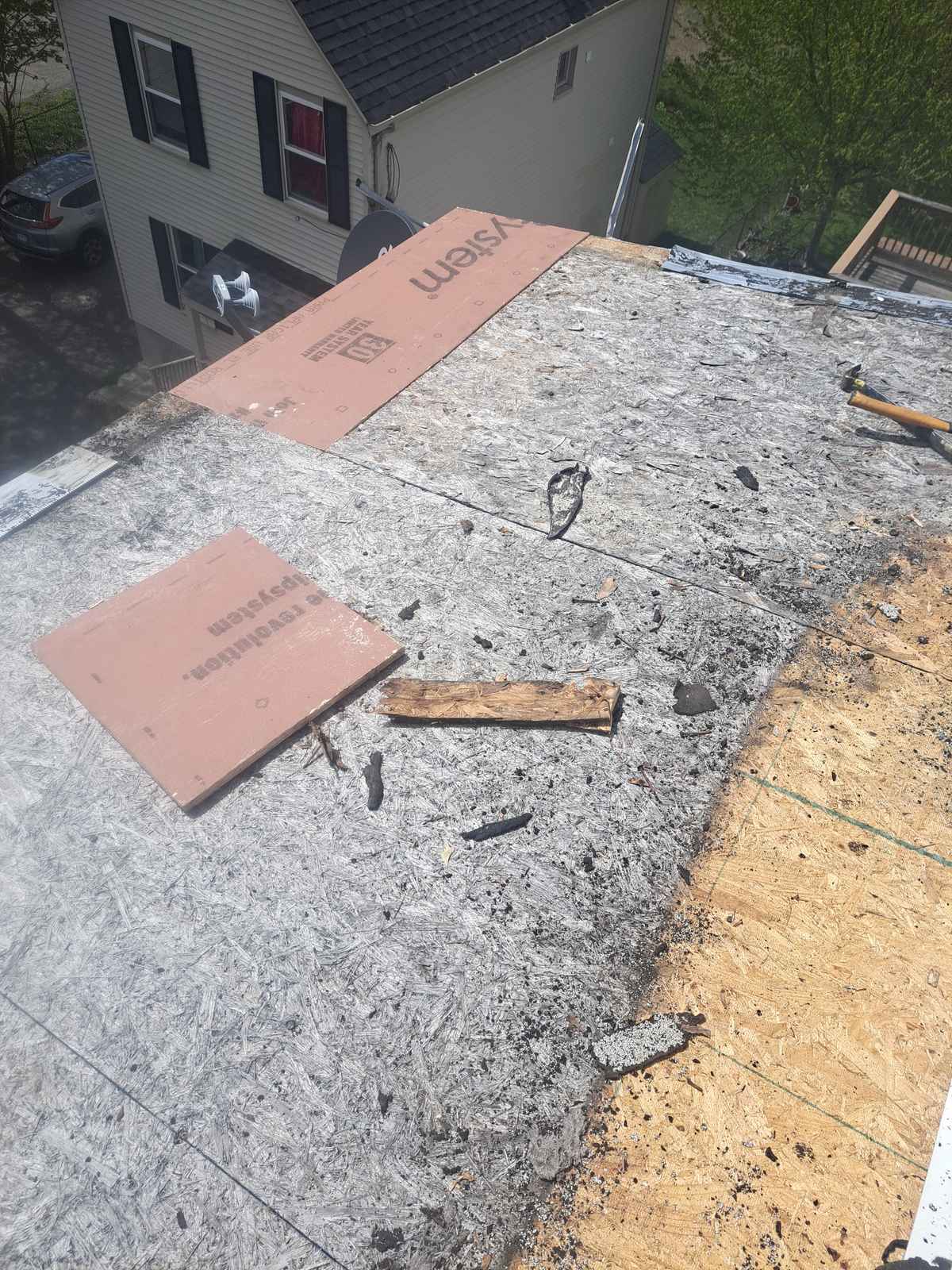 Roof deck with old underlayment and new ice-and-water shield during a repair