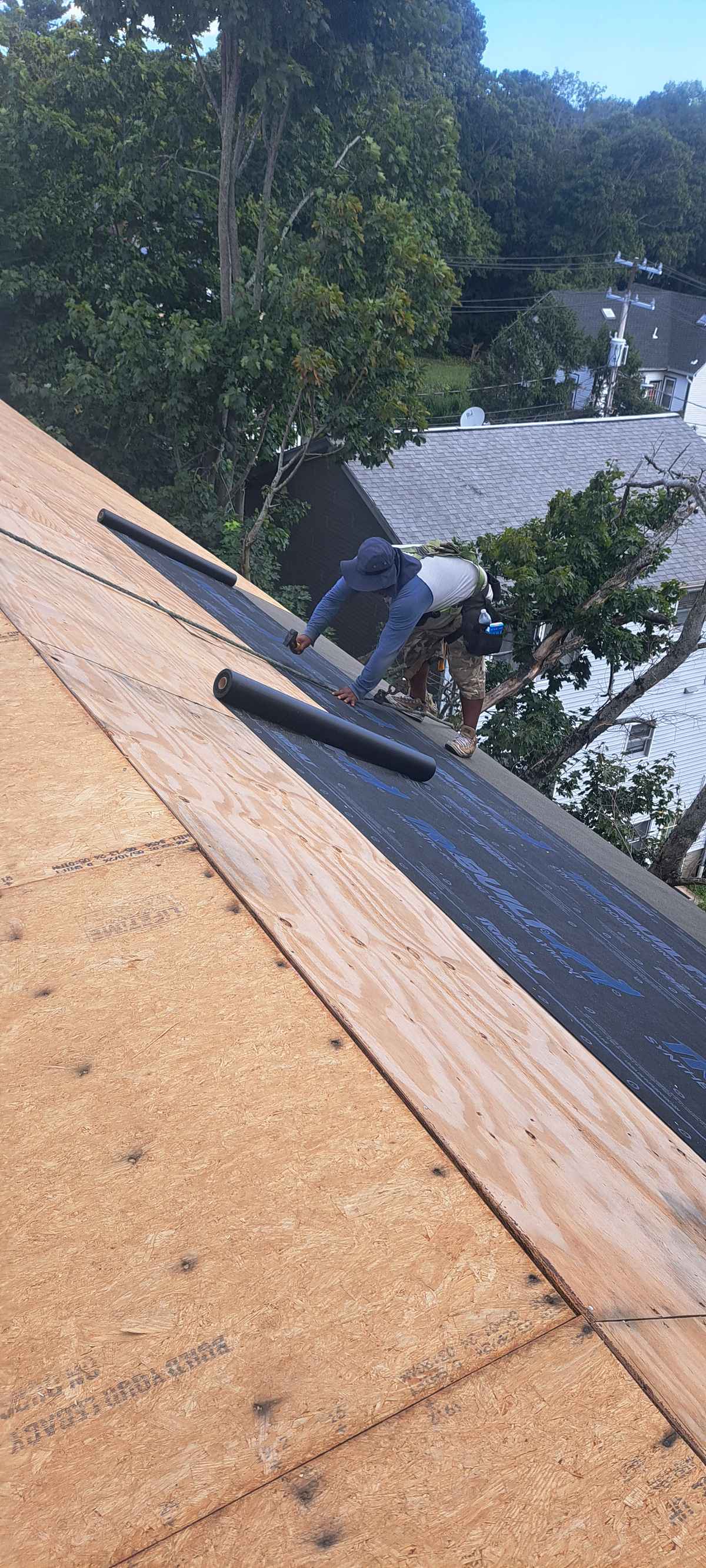 Rubber membrane being adhered along a parapet on a flat roof