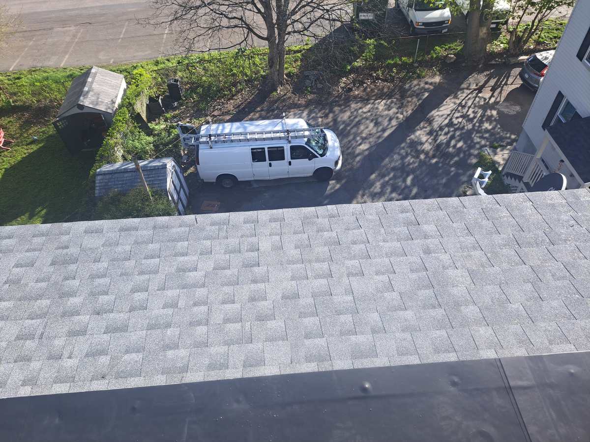 Completed gray asphalt shingle roof seen from above