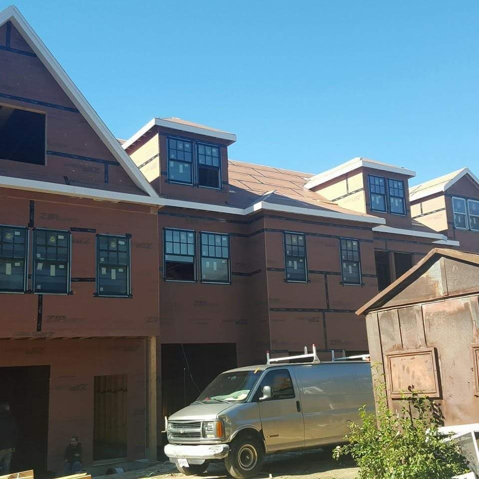 Newly built townhouses with finished roofs and house wrap on the walls